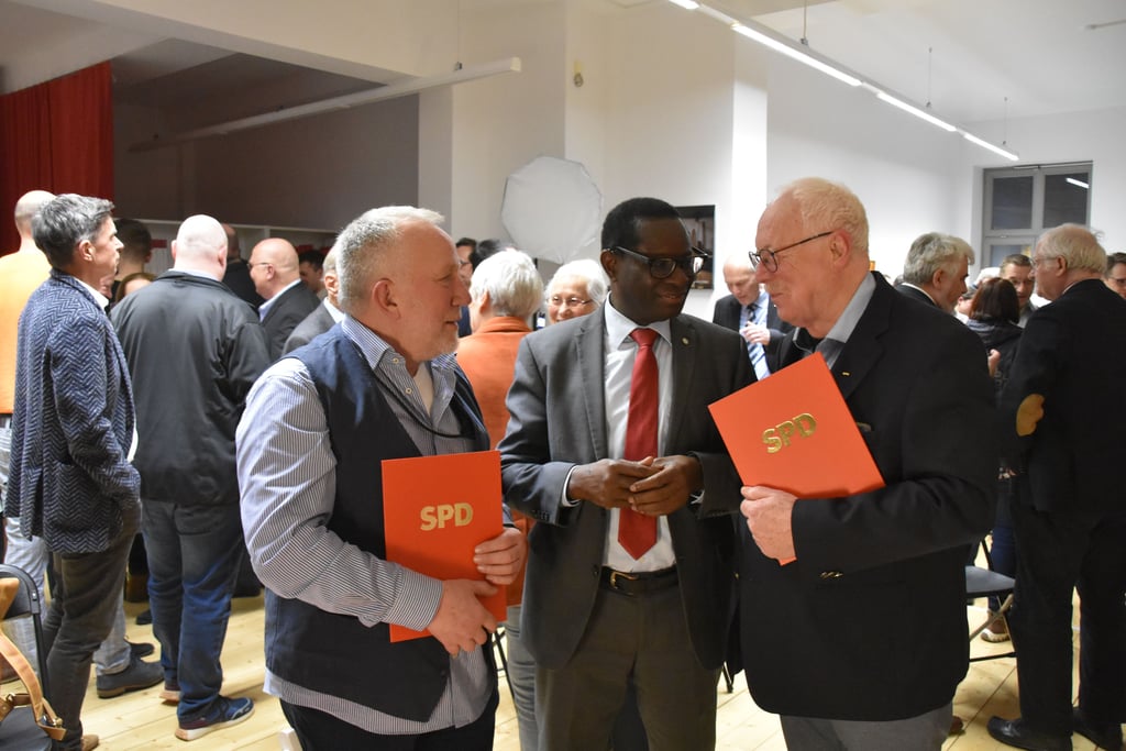 Für langjährige Mitgliedschaft ausgezeichnet: Die SPD-Mitglieder Günter Rink (l.) und Peter Dehn (r.) beim Neujahrsempfang der Partei im Gespräch mit dem SPD-Bundestagsabgeordneten Karamba Diaby