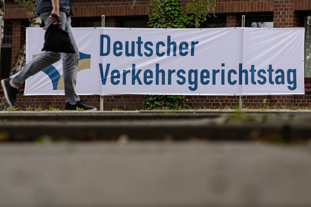 Ein Mann geht an einem Plakat mit der Aufschrift „Deutscher Verkehrsgerichtstag“ vorbei.
