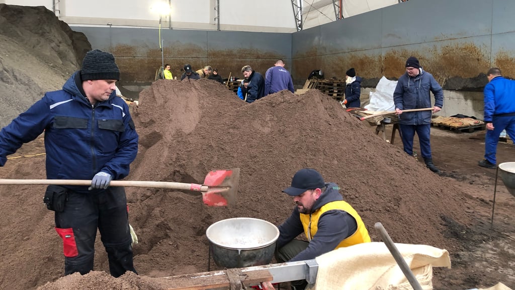 Auf dem Gelände des Baustoffunternehmens Papenburg bei Sangerhausen füllen zivile Helfer am 6. Janaur 2024 Sandsäcke.