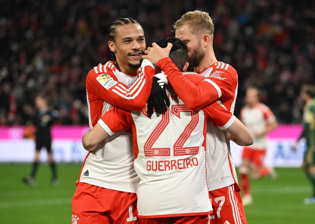Leroy Sane von München (l) und Konrad Laimer von München (r) gratulieren Raphael Guerreiro (M) zu seinem Führungstreffer.