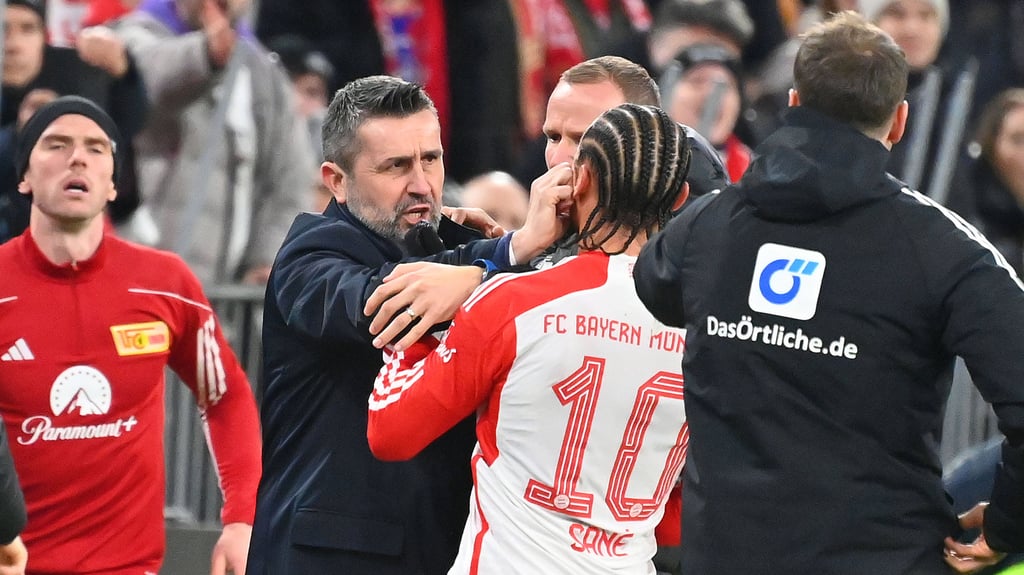 Union Berlins Trainer Nenad Bjelica greift Bayern-Spieler Leroy Sané ins Gesicht und sieht dafür die Rote Karte.