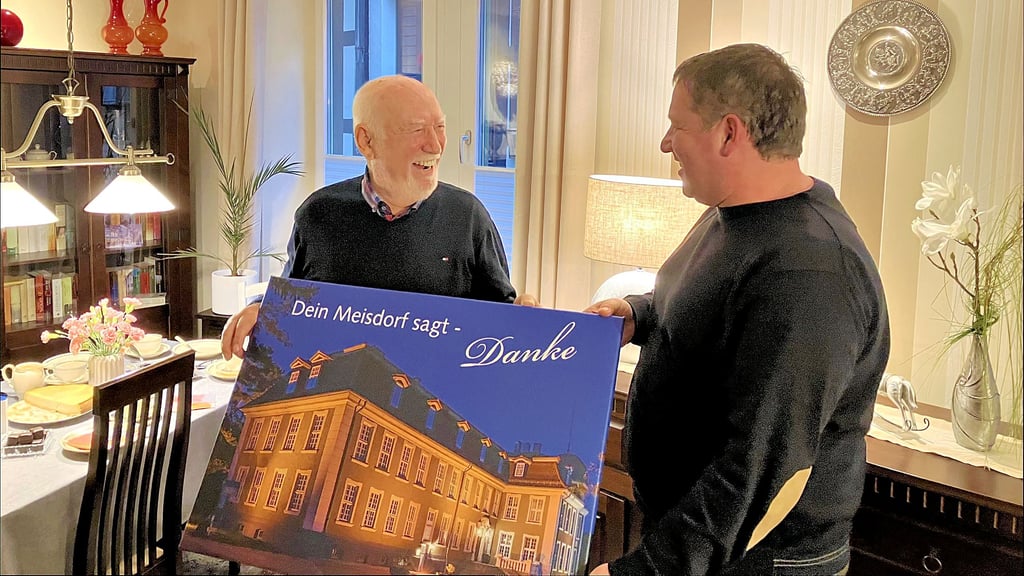 Meisdorfs Ortsbürgermeister Ralf Bianga (r.) übergibt Helmut Kühne eine Fotografie des Meisdorfer Schlosses.