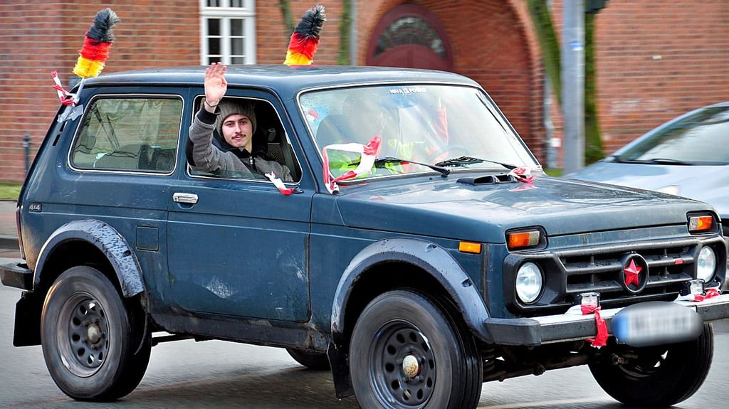 Mit Deutschlandflaggen und Flatterband bekunden die Menschen des Autokorsos in Stendal ihre Solidarität.