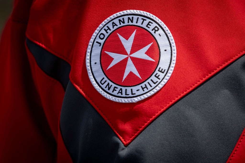 Das Logo der Johanniter-Unfall-Hilfe ist auf der Jacke eines Pressesprechers zu sehen.