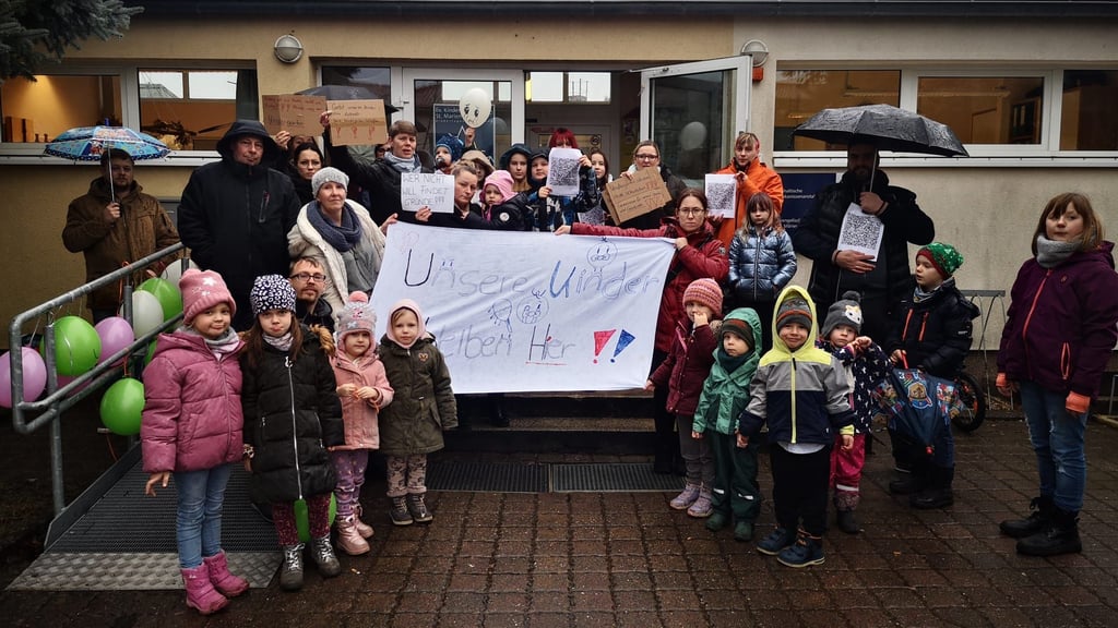 Eltern und Kinder am Freitagnachmittag vor der Kita in Roßlau. Die Forderung ist klar. 