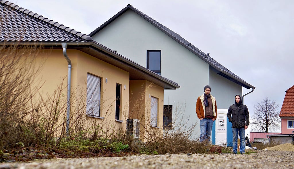 Ihre Häuser sind fertig, aber die Straße noch lange nicht: Noch können Alexander Querengässer und Jerome Huschka (r.) nicht einziehen.