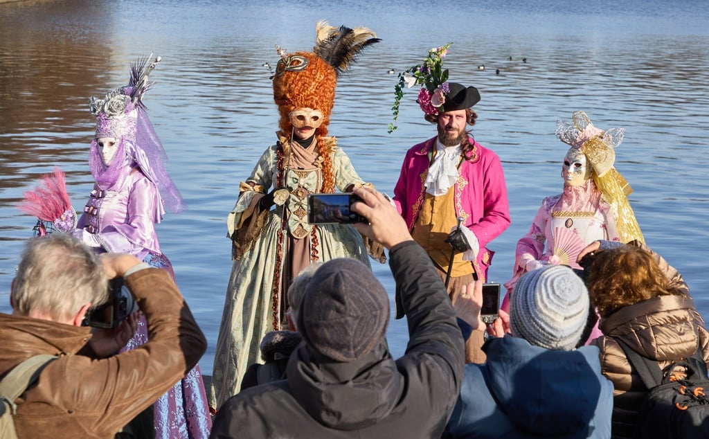 Verkleidete Karnevalfans haben viele neugierige Zuschauer an der Binnenalster in Hamburg.