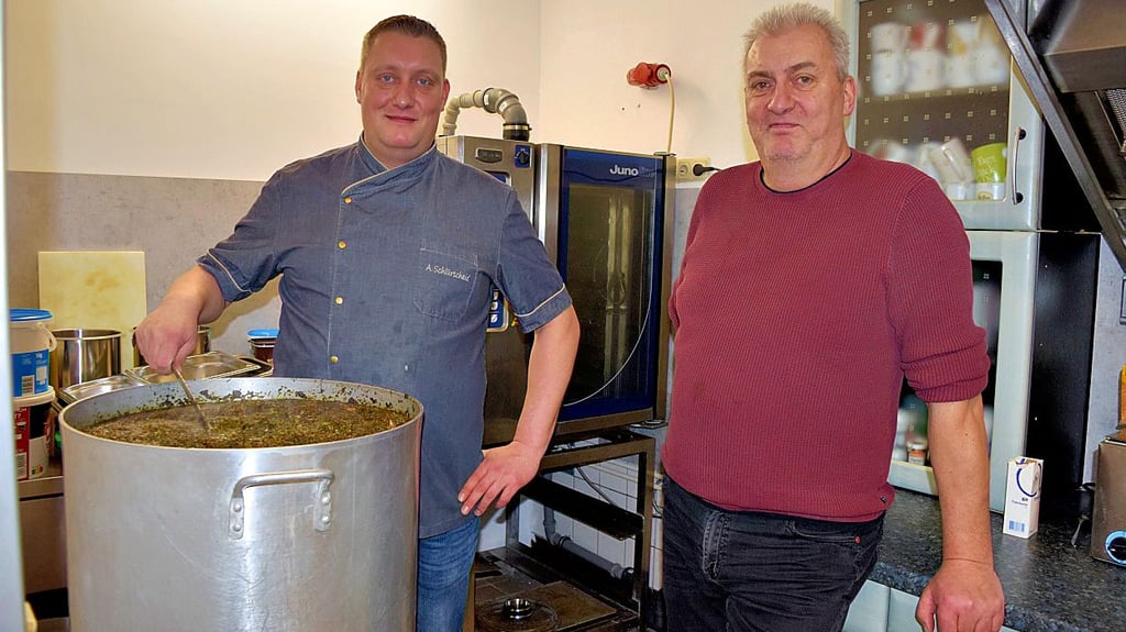 Ludger Schlürscheid (r.) schaut in die Küche, wo Sohn Andy Schlürscheid den Grünkohl kocht.