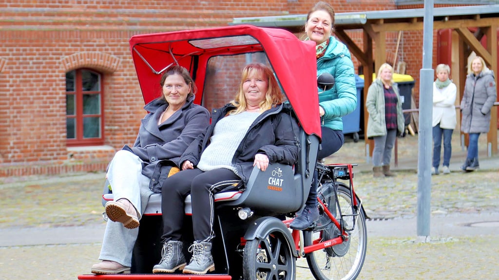 Susanne Käsdorf kutschiert zwei ihrer Bewohnerinnen mit der neuen Fahrrad-Rikscha über den Hof von „Sankt Clara“ auf der Domäne in Groß Ammensleben.