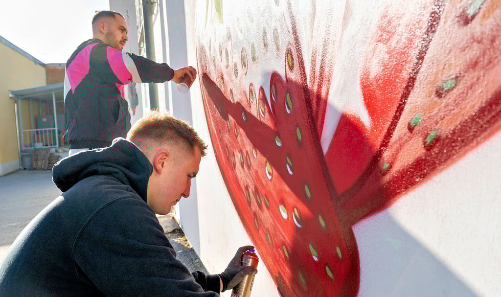 Mammut-Erdbeere am künftigen Cap-Markt: Die Graffiti-Sprayer Michael Hendrich (vorn) und Tim Heidler, alias „Dirty Fellows“, verzieren eine Wand.