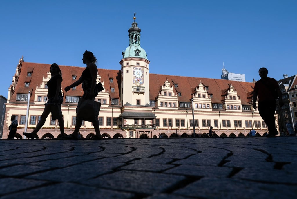 Passanten gehen auf dem Markt am Alten Rathaus in Leipzigs Stadtzentrum vorbei. Das historische Gebäude beherbergt seit 1909 das Stadtgeschichtliche Museum.