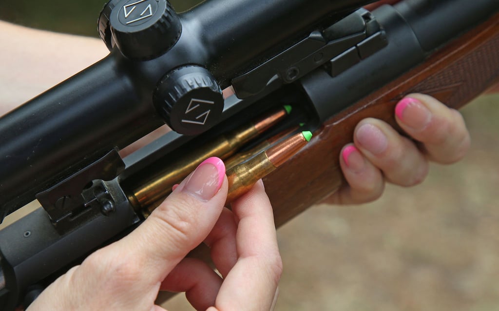 Eine Jägerin lädt ihre Jagdwaffe mit bleifreier Jagdmunition.