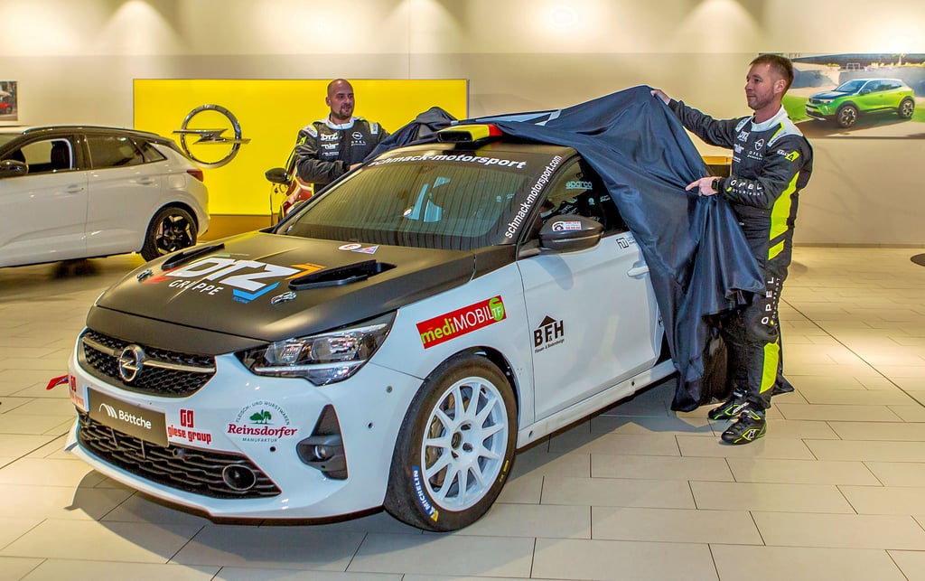 Fabian Hoese (li.) und Patrick Pusch enthüllen das neue Rallye-Fahrzeug im Wittenberger Opelhaus.