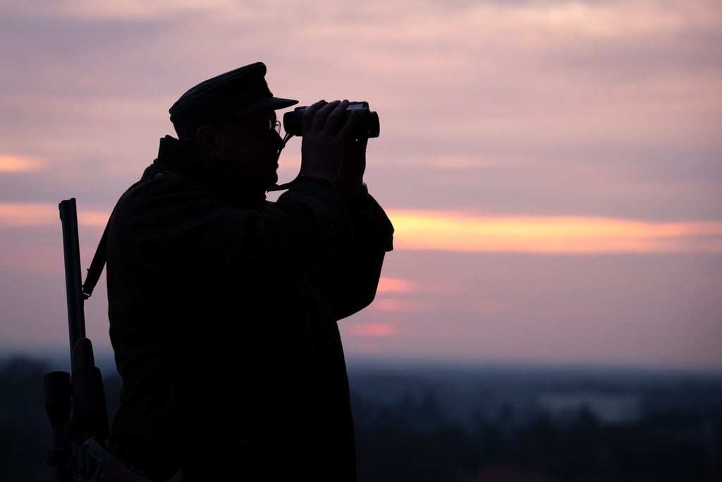 Ein Jäger blickt durch sein Fernglas in der Abenddämmerung. In Nordrhein-Westfalen startet die Messe Jagd & Hund.