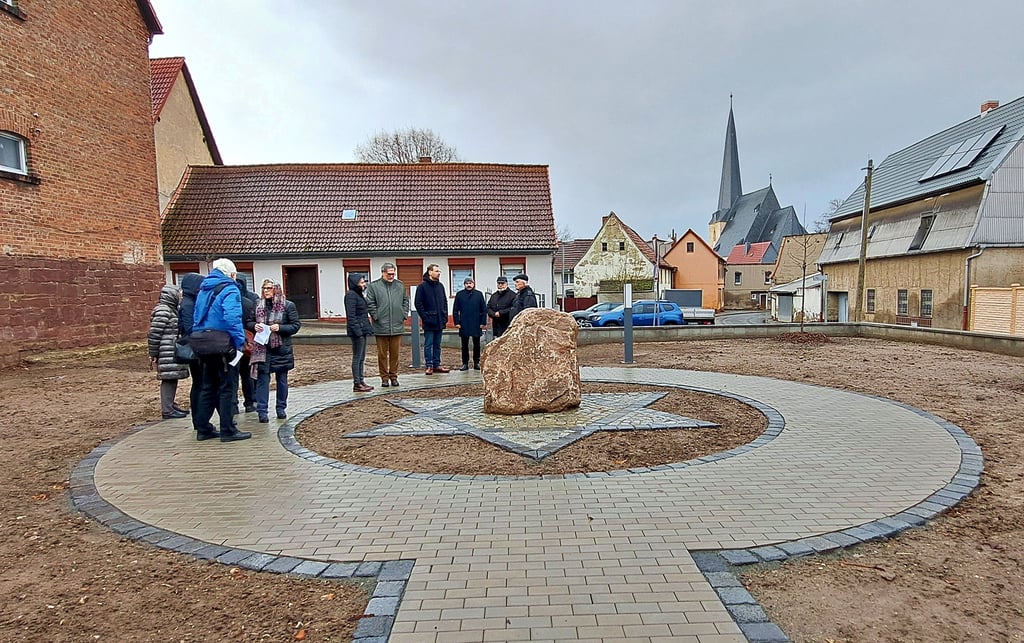 Vertreter der kirchengeschichtlichen Kammer der Landeskirche Anhalt haben sich gemeinsam mit Sanderslebens Ortsbürgermeisterin Nina Stähle und Arnsteins Bürgermeisterin Janet Klaus (SPD) die neue Gedenkstätte für die Synagoge in Sandersleben angeschaut.