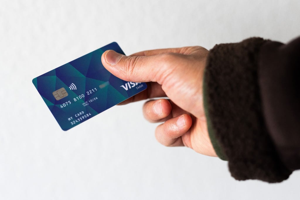Ein Geflüchteter hält eine Debitkarte in der Hand.