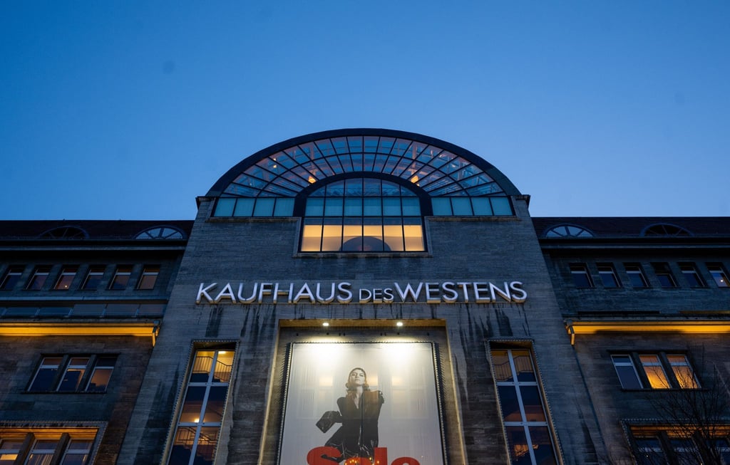 Die beleuchtete Kaufhaus des Westens (KaDeWe) ragt in den Abendhimmel.
