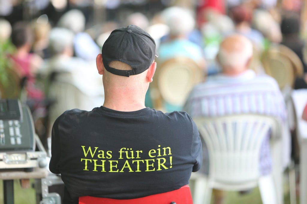Ein T-Shirt mit der Aufschrift „Was für ein Theater“ trägt ein Techniker während eines Picknickkonzertes von der Staatskapelle Halle und dem Theater Eisleben.