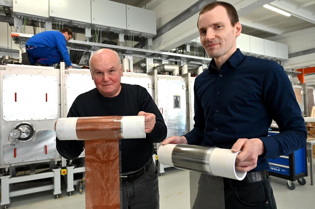 Geschäftsführer Manfred Danziger und Projektmanager Jens Harhausen zeigen die Efolion-Erfindung: Kupfer- und Aluminiumgewebe für Stromkollektoren. Im Hintergrund wird die Pilotanlage aufgebaut.