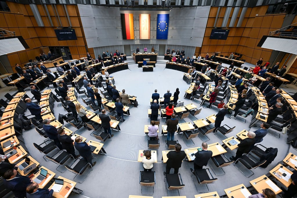 Abgeordnete stehen im Plenarsaal bei einer Plenarsitzung des Berliner Abgeordnetenhauses.