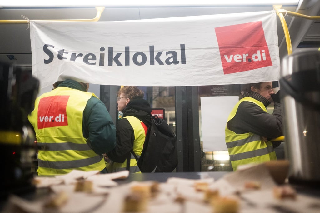 In einem Bus, der als Streiklokal dient, stehen vor dem BVG-Depot in der Cicerostraße Streikende.