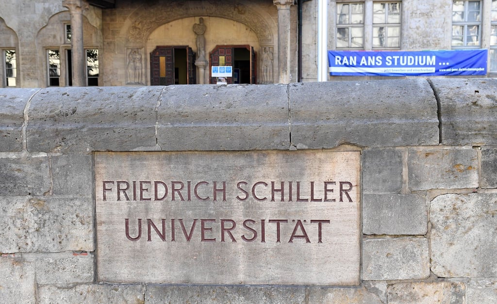 „Friedrich Schiller Universität“ steht am Eingang des Hauptgebäudes der Uni in Jena.