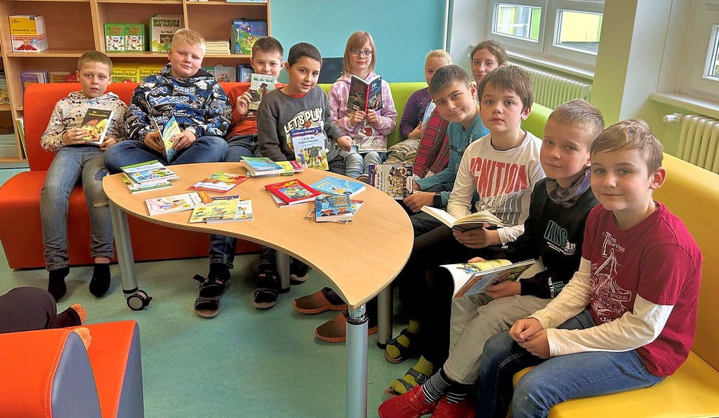 Einige Kinder der dritten Klasse stöbern in den neuen Büchern in ihrer Grundschule "Am Fliederhof" in Magdeburg-Olvenstedt.