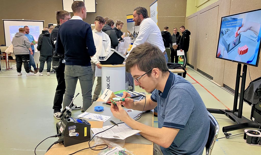 Schüler informieren sich bei der Azubi-Hausmesse über Ausbildungsunternehmen in Falkenstein. Tonfunk-Azubi Jonas Ecke gibt praktische Einblicke.