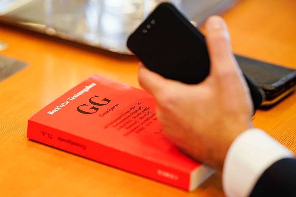 Ein Grundgesetz liegt im Verhandlungssaal des Bundesverfassungsgerichts auf einem Tisch. Eine Mehrheit der Deutschen sieht einer Umfrage zufolge die Demokratie in Deutschland in Gefahr.