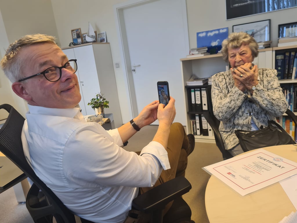 Professor Rüdiger Braun-Dullaeus macht ein Handyvideo von seiner 95 Jahre alten Patientin Maria Beck, die ihm ein Ständchen auf der Mundharmonika bringt. Der Genthinerin wurde eine künstliche Herzklappe (TAVI) eingesetzt.