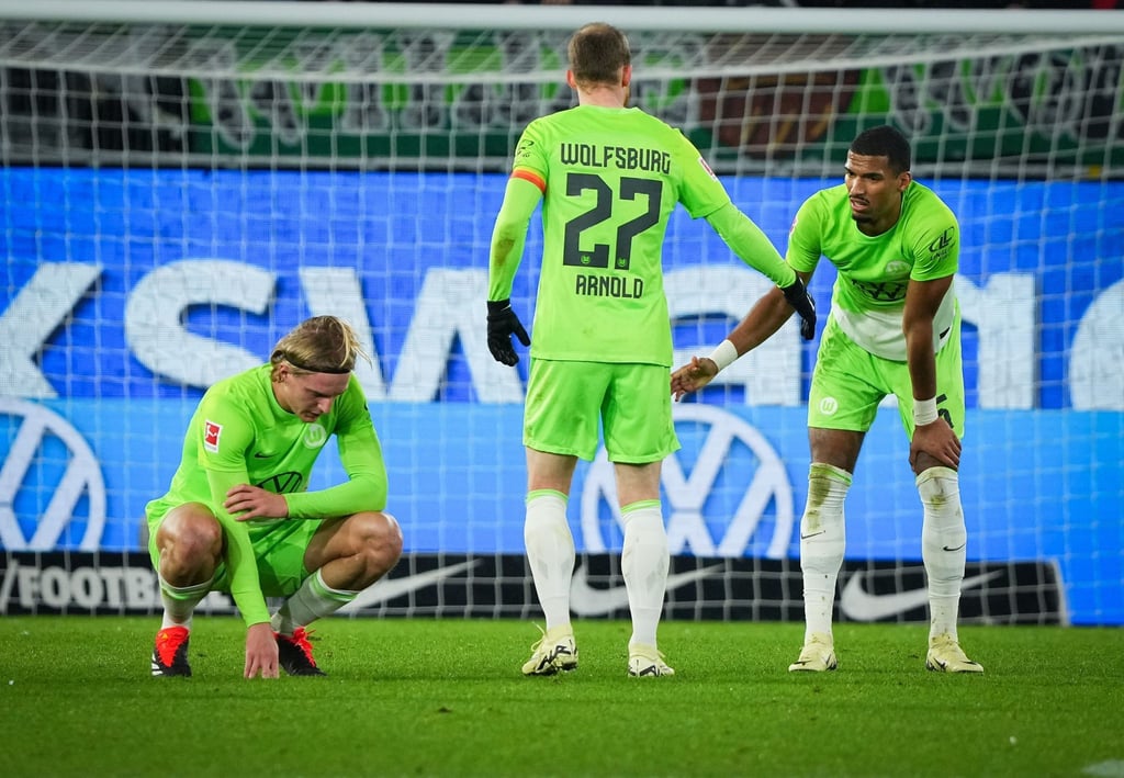 Sebastiaan Bornauw (l-r), Maximilian Arnold, und Cédric Zesiger von Wolfsburg zeigen sich nach dem Schlusspfiff enttäuscht.