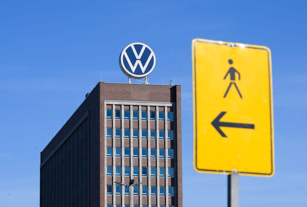 Ein Hinweisschild für Fußgänger steht in Sichtweite vom Markenhochhaus im Volkswagen-Stammwerk.