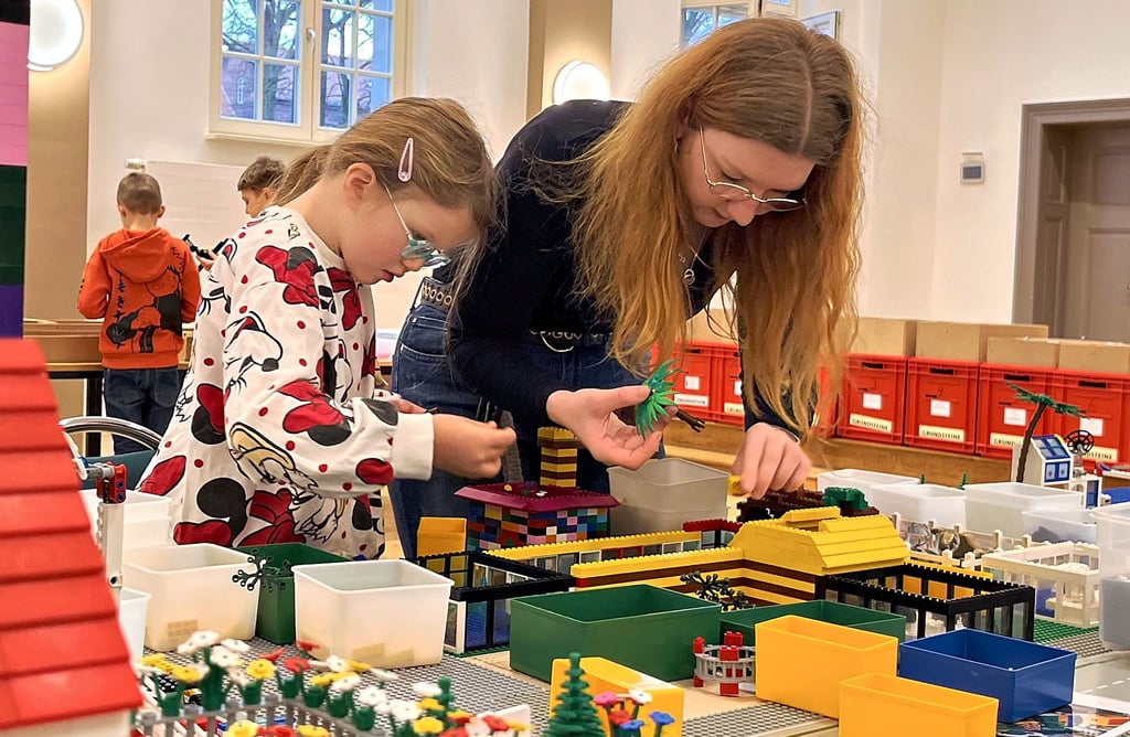 Noch ist auf der großen Platte Platz für Kisten mit unterschiedlich farbigen Legosteinen. Morgen werden überall Häuser, Autos und Stationen zu sehen sein.