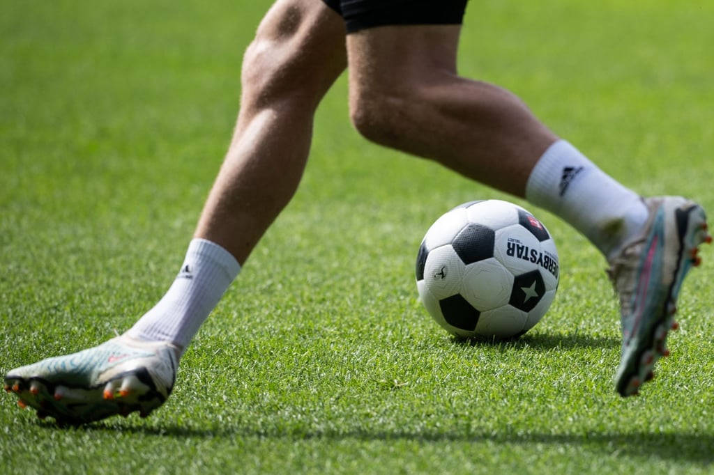 Ein Fußballer spielt den Ball.