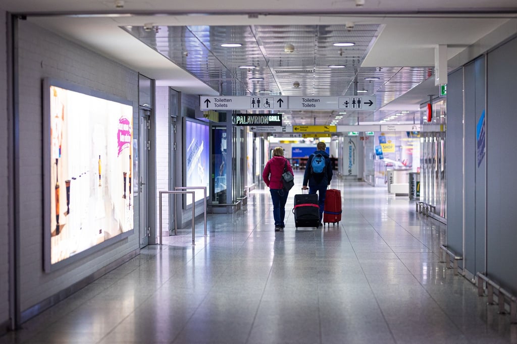 Reisende gehen am Morgen mit Koffern durch den Flughafen Hannover-Langenhagen.