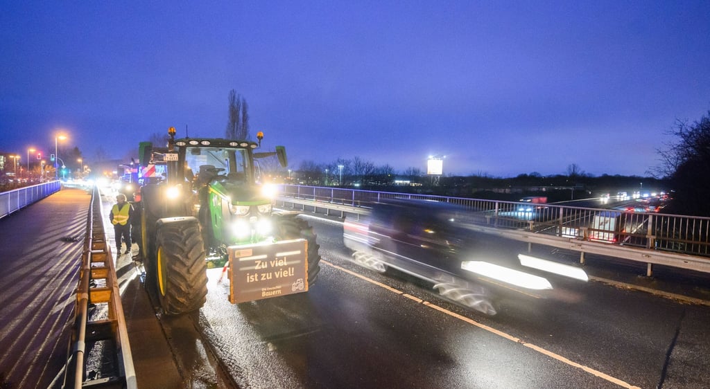 Bauern stehen mit Traktoren auf einer Brücke über der A2 bei Garbsen in der Region Hannover.