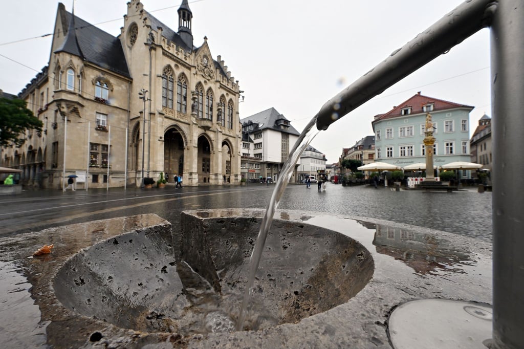 Wasser läuft aus einem Trinkbrunnen auf dem Fischmarkt vor dem Erfurter Rathaus.