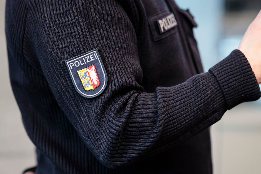 Ein Beamter trägt einen Pullover mit dem Wappen der Polizei Schleswig-Holstein.