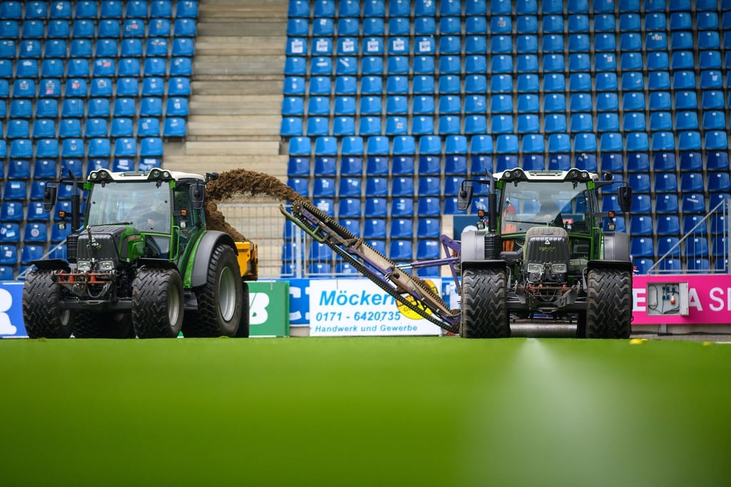 Arbeiter entfernen in der MDCC-Arena vom 1. FC Magdeburg mit einer Fräse den Rasen des Stadions.