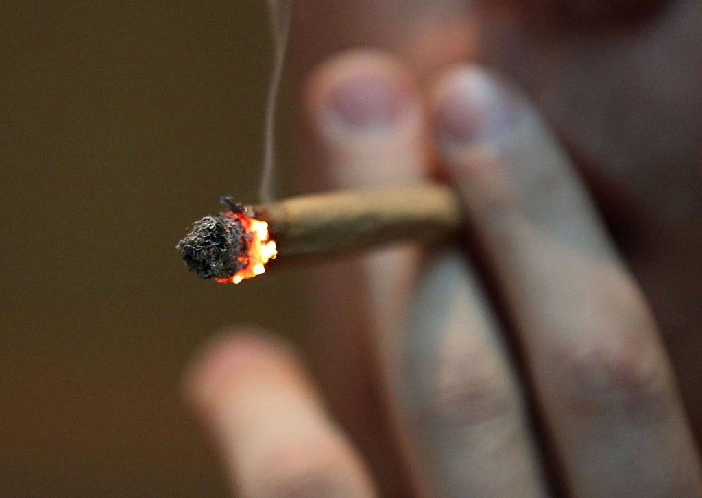 Ein Mann raucht in einem Coffee Shop Marihuana.