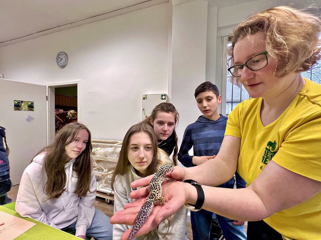 Tierparkpädagogin Katja Flügel zeigt den Workshopteilnehmern einen Leopardgecko.