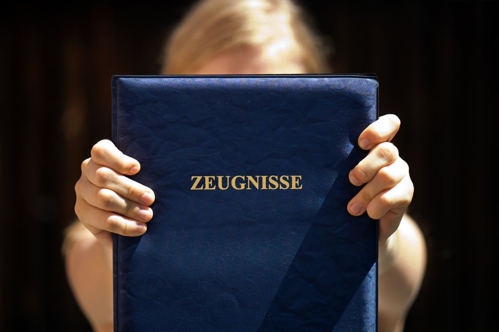 Eine Schülerin hält ihre Mappe mit ihren Zeugnissen in den Händen.
