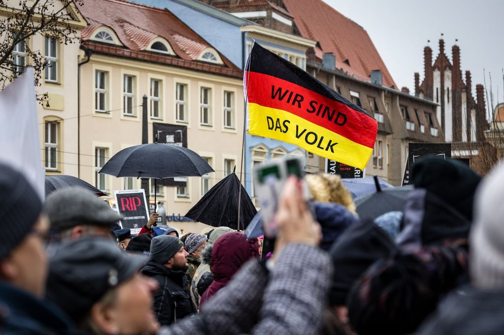„Wir sind das Volk“ steht auf einer schwarz-rot-goldenen Fahne bei einer Kundgebung auf dem Altmarkt.