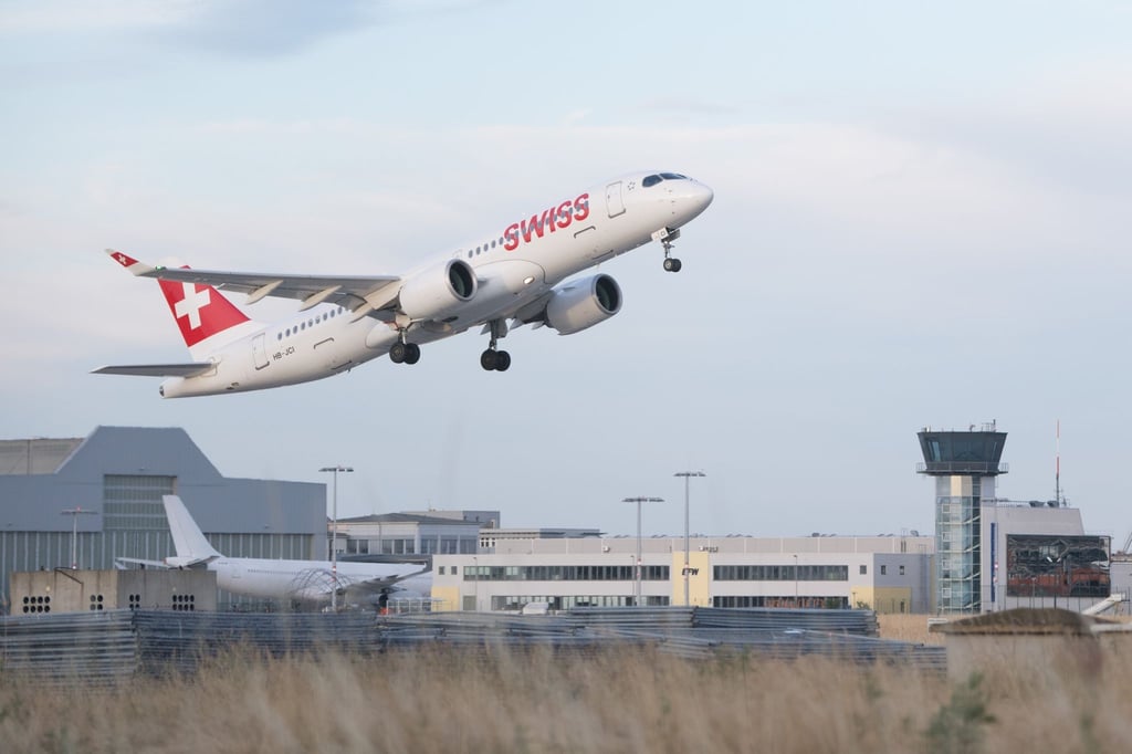 Eine Bombardier CS300 startet auf dem Flughafen Dresden International vor dem Tower.