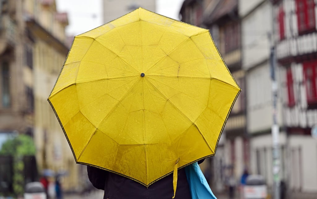Eine Frau hält einen Regenschirm.