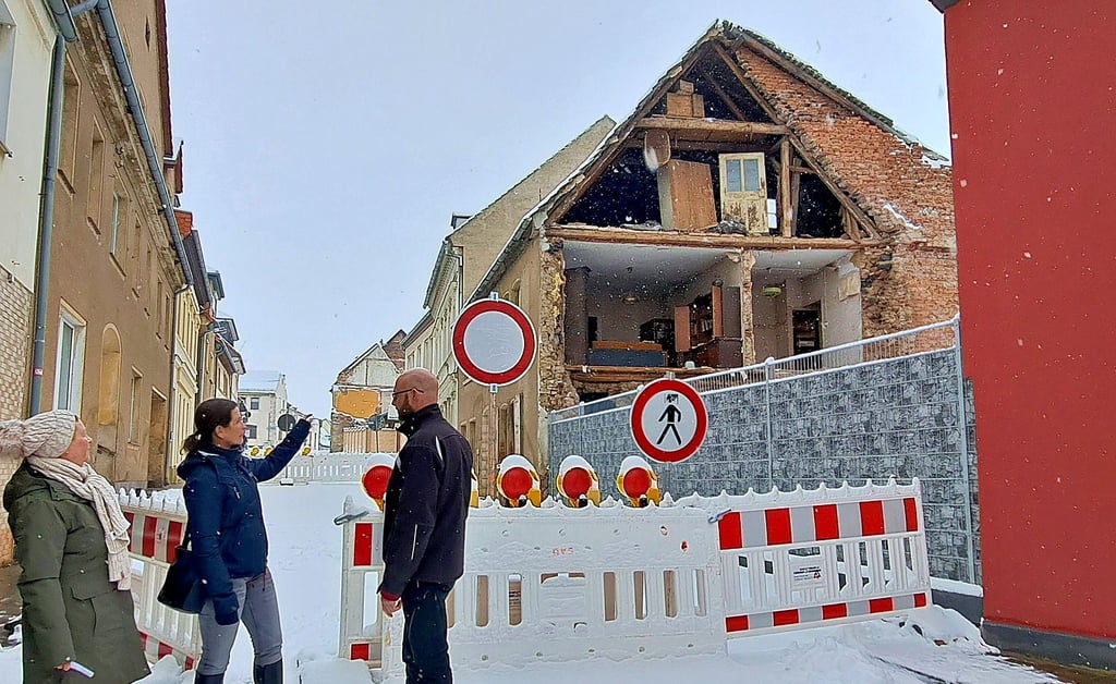 Der Giebel des Wohnhauses in der Bernburger Straße war im Dezember 2023 abgestürtr: Ortsbürgermeisterin Nina Stähle (Mitte) und Anwohner wie Gabi Laube (li.) und Marcus Lindner sorgen sich, dass noch mehr zusammenstürzt.