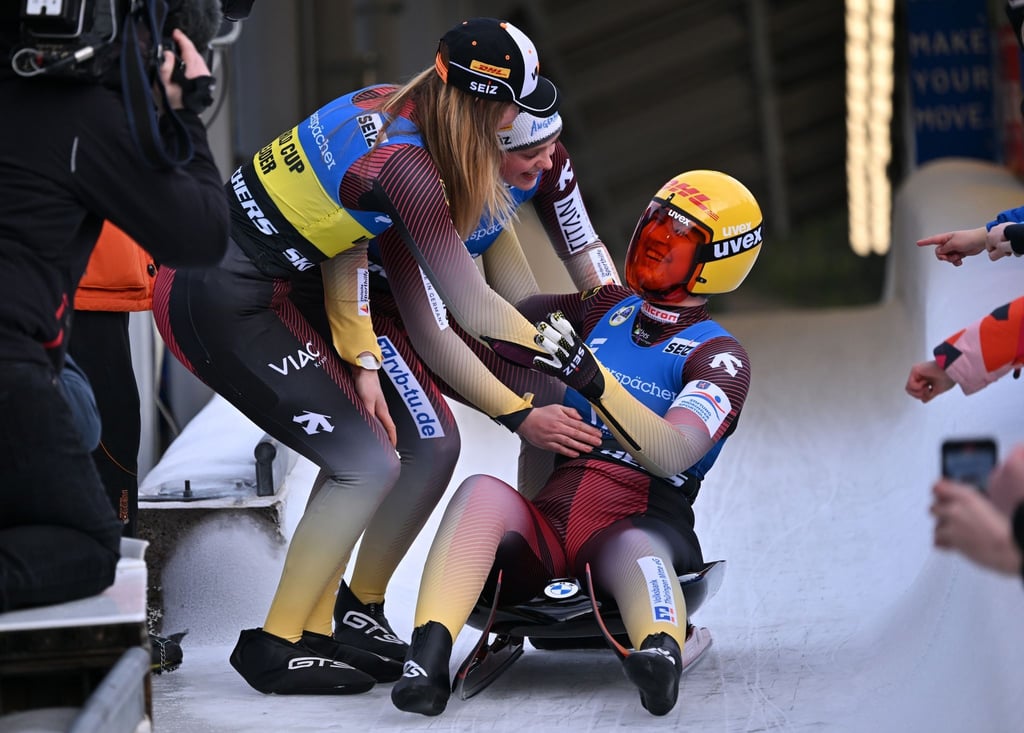 Julia Taubitz (l-r) , Anna Berreiter und Merle Fräbel aus Deutschland freuen sich gemeinsam im Ziel.