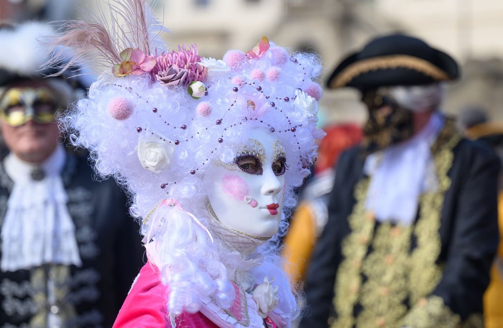 Teilnehmer stehen vor Beginn des Elbvenezianischen Carnevals vor der Frauenkirche auf dem Neumarkt.