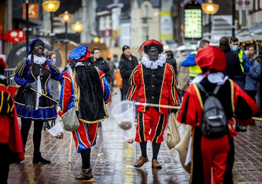 Anhänger der Anti-Islam-Bewegung Pegida mit Blackfacing stehen auf dem Marktplatz.