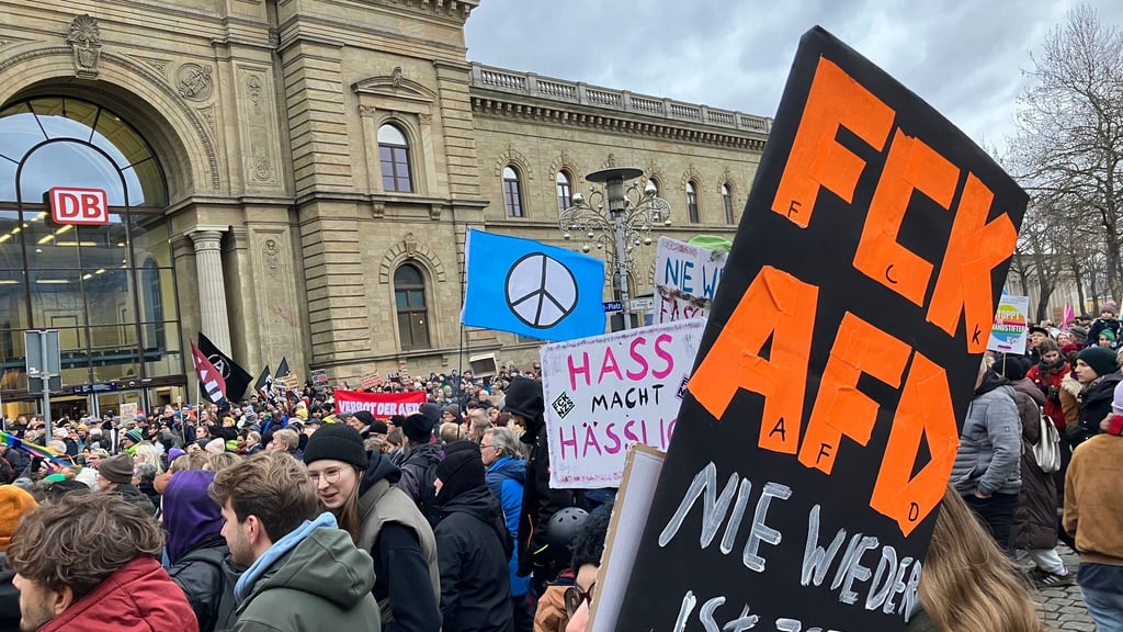 Demonstranten stehen mit Plakaten vor dem Magdeburger Hauptbahnhof bei einer Demonstration gegen rechts.